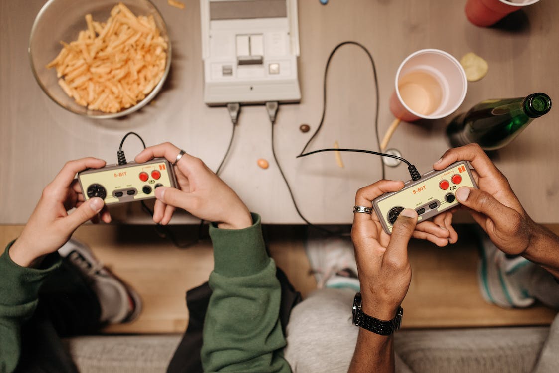 Two sets of hands playing video games